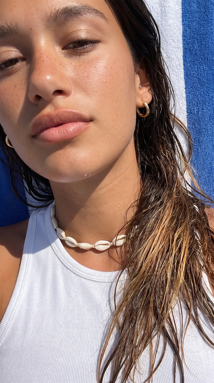 Chiara close up after a swim, wet hair and a shell necklace