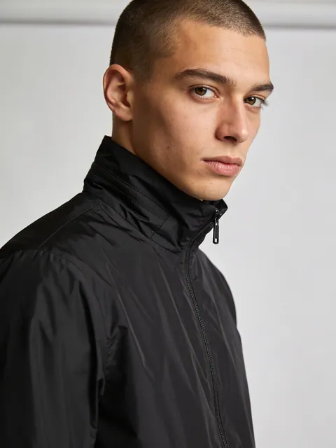 Generated studio portrait, a young man in a black shell jacket